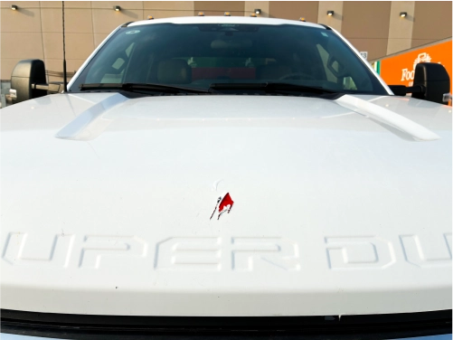 Chipped and damaged hood graphic on a wrapped Ford Super Duty truck