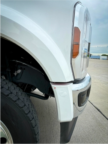 Close-up of a truck fender and wheel well where wrap edges are prone to lifting and curb rash