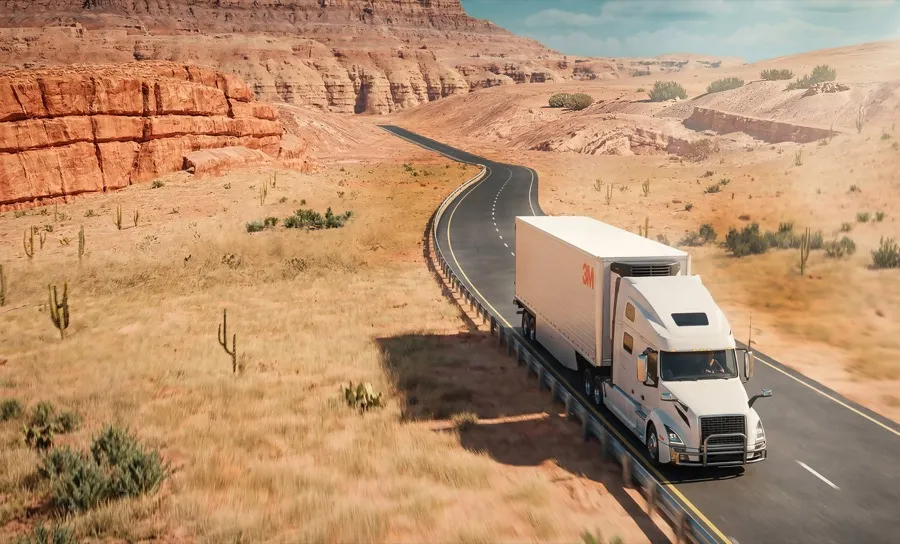 Semi truck pulling a white refrigerated trailer with 3M Cooling Film on the roof along a desert highway